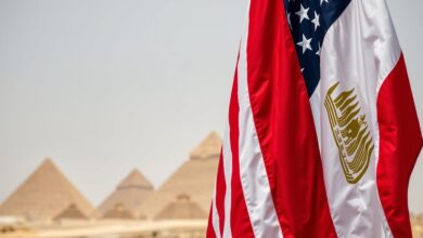 Bendera Amerika Serikat dan Mesir berdampingan dengan latar belakang piramida, melambangkan Hubungan Strategis Mesir-AS
